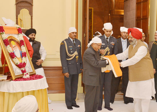 The President of India, Shri Pranab Mukherjee being presented with a shawl and saropa by Shri Balbir Singh at Rashtrapati Bhavan on November 28, 2012 at the Gurubani Recital on the occasion of the birthday of Guru Nanak Devji.